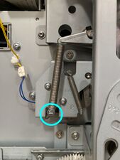 The separator spring, which should be detached at the marked point.