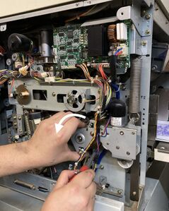 Tightening the 3 paper feed clutch base screws while turning the clutch unit counterclockwise, tensioning the belt.