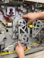 Removing the main drive cover while pressing in on the main pulley.