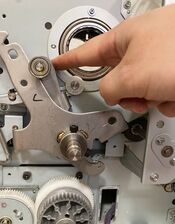 Pushing the pressure cam arm to the left.