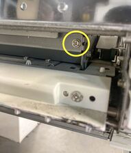 One of the 2 screws removed from the left of the MMU, while the unit cover is in the closed position.