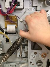 Right hand is braced on the top of main drive cage while the thumb grips under the tab on the end of the pressure lever.